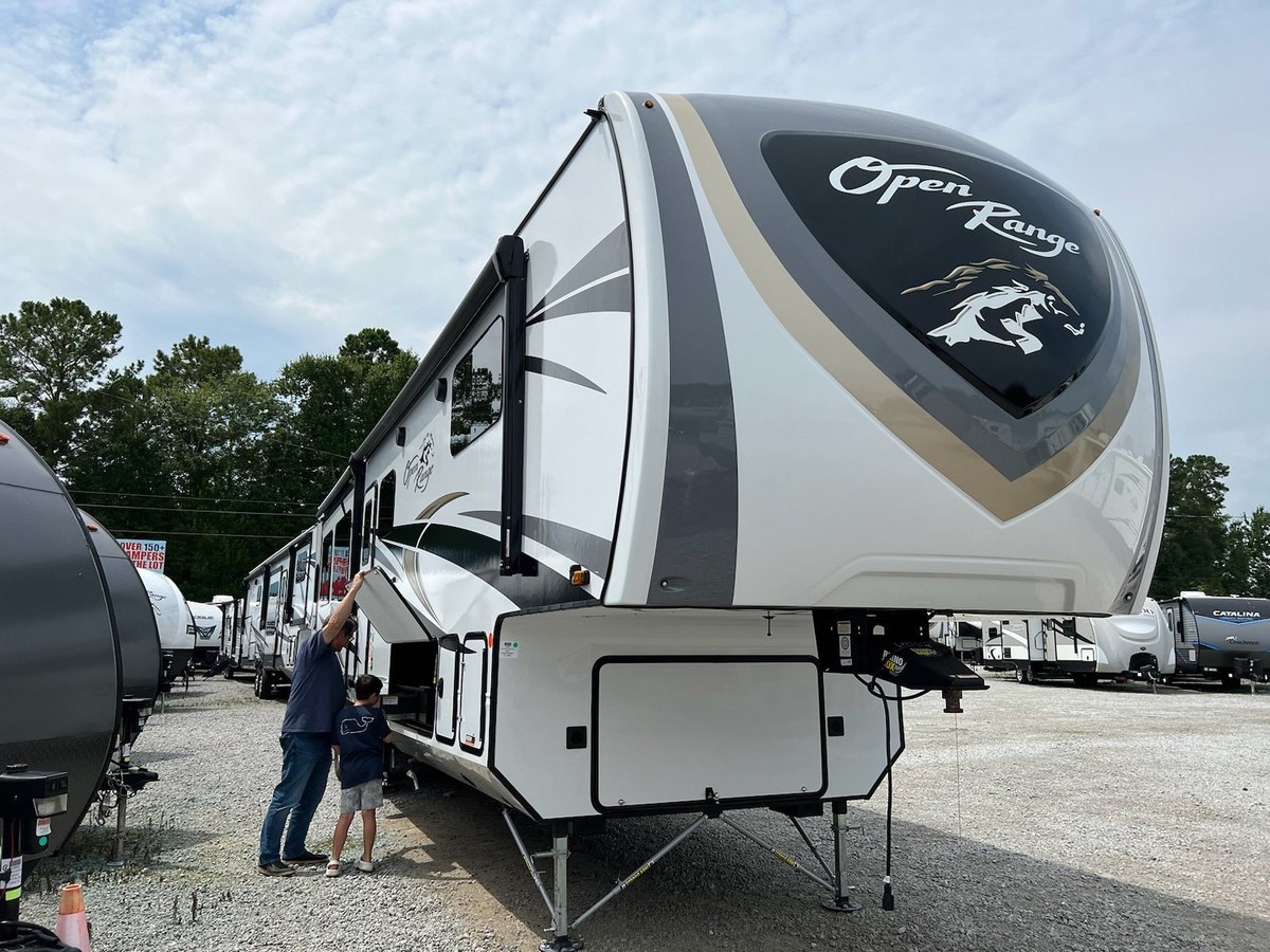 Big rigs on the gravel full-hookup sites among the pines